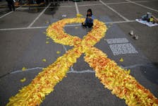 A girl sits inside a large yellow coloured ribbon dedicated to victims of the sunken Sewol ferry disaster that killed 304 people, mostly school students, during a ceremony to commemorate its tenth anniversary in Ansan, South Korea, April 16, 2024.