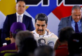 Venezuela's President Nicolas Maduro holds an placard with images of Simon Bolivar and Hugo Chavez as he attends to register as candidate in the upcoming presidential election to secure another six-year term, in Caracas, Venezuela March 25, 2024.