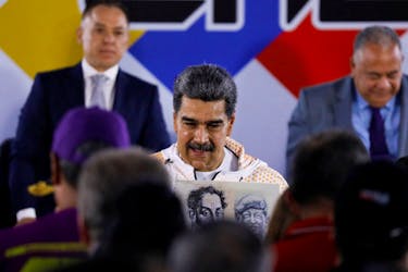 Venezuela's President Nicolas Maduro holds an placard with images of Simon Bolivar and Hugo Chavez as he attends to register as candidate in the upcoming presidential election to secure another six-year term, in Caracas, Venezuela March 25, 2024.