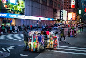 A man pushes his cart with merchandise to sell, in Times Square, New York, U.S., December 25, 2023.