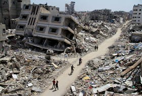 Palestinians ride bicycles past the ruins of houses and buildings destroyed during Israel’ military offensive, amid the ongoing conflict between Israel and the Palestinian Islamist group Hamas, in the northern Gaza Strip March 31, 2024.