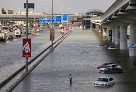 A person stands surrounded by flood water caused by heavy rains, in Dubai, United Arab Emirates, April 17, 2024.