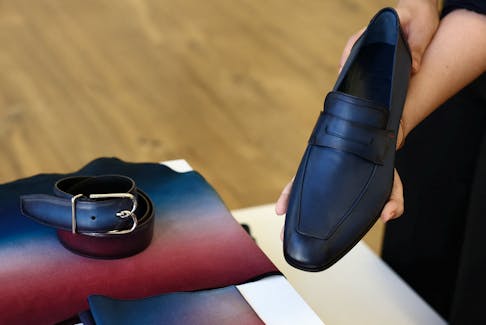 An employee shows a moccasin shoe that will be worn by the French team athletes for the opening ceremony by LVMH's upscale menswear label Berluti, in a showroom at Berluti headquarters in Paris, France, April 10, 2024.