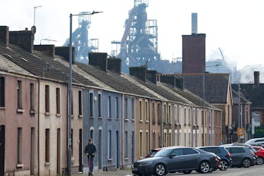 File photo: A person rides a scooter along a residential street with Tata Steel Port Talbot steel production plant seen behind, ahead of its planned transition from blast furnace to electric arc furnaces, at Port Talbot, Wales, Britain, March 11, 2024.