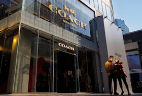 People walk past a store of the Coach luxury fashion retailer in a shopping district in Beijing, China, October 19, 2022.