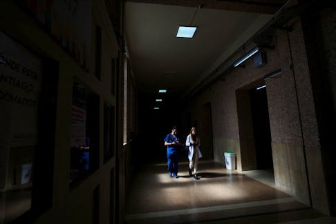 Medical students walk in a hallway of the University of Buenos Aires Medical School in the dark, as the university has to restrict the use of electricity due to budget cuts, in the run-up to a national strike on April 23 against Argentina's President Javier Milei's policy of cuts in public education, in Buenos Aires, Argentina April 17, 2024.