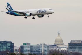 An Alaska Airlines aircraft flies past the U.S. Capitol before landing at Reagan National Airport in Arlington, Virginia, U.S., January 24, 2022.  