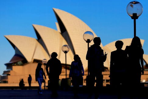 People are silhouetted against the Sydney Opera House at sunset in Australia, November 2, 2016.  