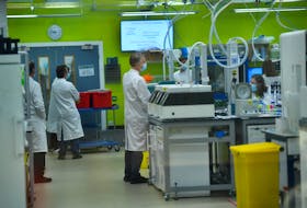 Scientists work at a laboratory where they sequence the novel coronavirus genomes at COVID-19 Genomics UK, on the Wellcome Sanger Institute's 55-acre campus south of Cambridge, Britain March 12, 2021. Picture taken March 12, 2021. 