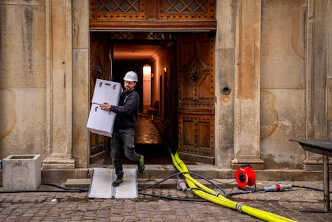 A man carries boxes as moving work is underway in the preserved part of the Old Stock Exchange building in Copenhagen, Denmark, April 17, 2024. Ritzau Scanpix/Ida Marie Odgaard via REUTERS