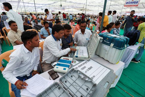 Election staff check the Electronic Voting Machines (EVM) at a polling station, ahead of the first phase of the election, in Bikaner, Rajasthan, India, April 18, 2024.