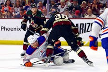 Apr 17, 2024; Tempe, Arizona, USA;  Edmonton Oilers left wing Dylan Holloway (55) moves the puck against Arizona Coyotes center Liam O'Brien (38) during the first period at Mullett Arena. Mandatory Credit: Mark J. Rebilas-USA TODAY Sports