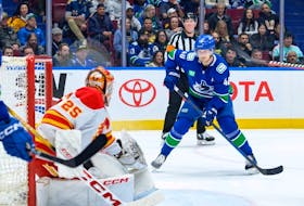 Vancouver's Elias Pettersson faces former Canuck Jacob Markstrom of the Calgary Flames during NHL action at Rogers Arena on March 23.