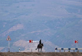 A man rides a horse along a road near the Armenia-Azerbaijan border outside the village of Kornidzor, Armenia, September 23, 2023.