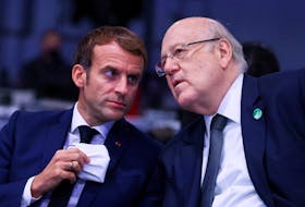 Lebanese Prime Minister Najib Mikati speaks with French President Emmanuel Macron, as they attend the UN Climate Change Conference (COP26) in Glasgow, Scotland, Britain, November 1, 2021.