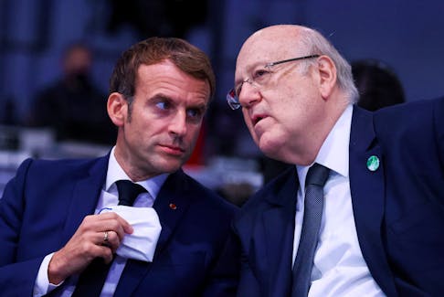 Lebanese Prime Minister Najib Mikati speaks with French President Emmanuel Macron, as they attend the UN Climate Change Conference (COP26) in Glasgow, Scotland, Britain, November 1, 2021.
