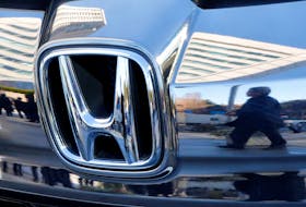 People are reflected on a Honda Motor car outside the company's headquarters in Tokyo, Japan February 2, 2017.  Picture taken February 2, 2017.  