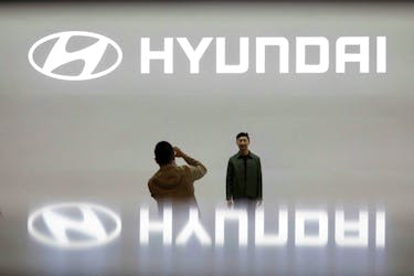 Visitors take photographs in front of the logo of Hyundai Motor during the 2019 Seoul Motor Show in Goyang, South Korea, March 28, 2019.