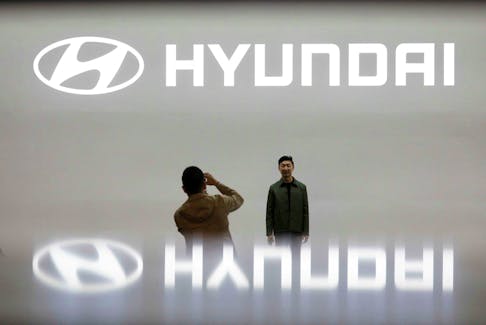 Visitors take photographs in front of the logo of Hyundai Motor during the 2019 Seoul Motor Show in Goyang, South Korea, March 28, 2019.