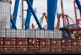 A worker stands on a container at Tanjung Priok Port in Jakarta, Indonesia, January 11, 2021. Picture taken January 11, 2021.