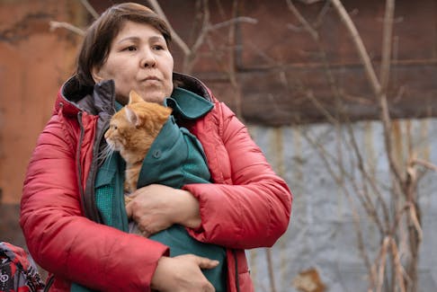 A woman holds a cat during the evacuation of residents from a flooded residential area in Petropavl, Kazakhstan April 13, 2024.