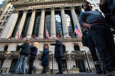 People walk outside the New York Stock Exchange in New York, U.S., December 29, 2023.
