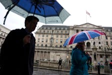 A tourist shelters from the rain under an Union Jack umbrella near the Bank of England in the City of London financial district in London, Britain, February 13, 2024.