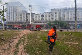A municipal worker removes debris at a site of an apartment building hit by a Russian missile strike, amid Russia's attack on Ukraine, in Dnipro, Ukraine April 19, 2024.