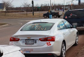 "Make Canada Trudeauless again" and "Axe the Tax" stickers display on one of the protestors' car. Pratik Bhattarai • The Guardian