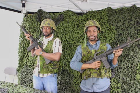 Mubarak (left) and Ridwan Mustapha try on Canadian Armed Forces equipment and guns at a job fair hosted at the Victoria Park garrison in Sydney on Saturday. The event is one of close to 100 recruiting events nationwide put on by the Canadian Army Reserves and armed forces this month, in an effort to boost recruitment. LUKE DYMENT/CAPE BRETON POST