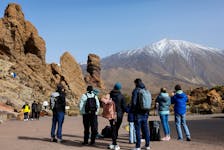 A group of tourists prepares to walk near the snowy Teide mountain after the heavy rains of the last few days in Las Canadas del Teide on the island of Tenerife, Spain, March 25, 2024.