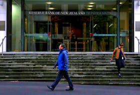 Pedestrians walk near the main entrance to the Reserve Bank of New Zealand located in central Wellington, New Zealand, July 3, 2017.