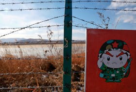 A cartoon soldier is depicted on part of a warning sign on barbed wire on the Chinese side of the border between Russia, China and North Korea near the town of Hunchun, China, November 24, 2017.