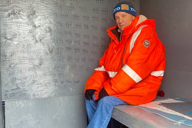 Jack Whalen, 63, sits in a replica of the isolation cell he spent 730 days in as a youth in the former Whitbourne Boys' Home. He is lobbying the government to remove the statute of limitations on childhood physical abuse, and travelled from Ottawa to bring the replica cell to Confederation Building in St. John's June 12, 2023. TARA BRADBURY • THE TELEGRAM
