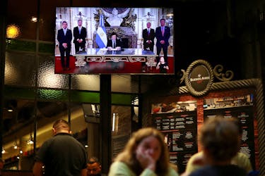 A screen shows Argentina's President Javier Milei addressing to the people on national TV as people dine in a restaurant, in Buenos Aires, Argentina, April 22, 2024.