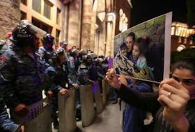 A protester shows a photograph near the government building during a rally to support ethnic Armenians in Nagorno-Karabakh following Azerbaijani armed forces' offensive operation executed in the region, in Yerevan, Armenia, September 20, 2023.