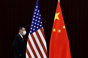 A man walks past the national flags of China and the U.S. before a meeting between China's Vice Premier He Lifeng and U.S. Treasury Secretary Janet Yellen at the Guangdong Zhudao Guest House, in Guangzhou, Guangdong province, China, April 6, 2024.