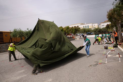 Emergency services personnel set up a tent at the premises of a hotel during the large scale earthquake preparedness "Minoas 2024" drill in the city of Heraklion on the island of Crete, Greece, April 23, 2024.