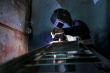 A worker welds steel pipes to make a counter at a steel furniture manufacturing unit in Ahmedabad, India September 1, 2016.