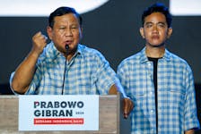 Indonesia's Defence Minister and leading Presidential candidate Prabowo Subianto delivers his speech as his running mate Gibran Rakabuming Raka, the eldest son of Indonesian President Joko Widodo and current Surakarta's Mayor, stands, as they claim victory after unofficial vote counts during an event to watch the results of the general election in Jakarta, Indonesia, February 14, 2024.