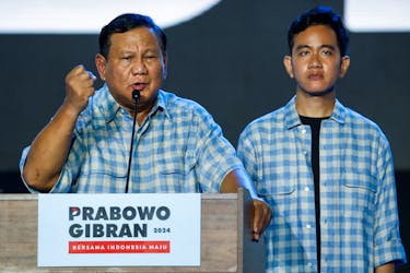 Indonesia's Defence Minister and leading Presidential candidate Prabowo Subianto delivers his speech as his running mate Gibran Rakabuming Raka, the eldest son of Indonesian President Joko Widodo and current Surakarta's Mayor, stands, as they claim victory after unofficial vote counts during an event to watch the results of the general election in Jakarta, Indonesia, February 14, 2024.