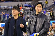 Los Angeles Dodgers player Shohei Ohtani, right, is shown with interpreter Ippei Mizuhara during an NFL game earlier this year. Mizuhara was fired by the team amid allegations he had engaged in "massive theft" from Ohtani to pay off gambling debts, multiple news outlets reported.  Kirby Lee-USA TODAY Sports/FILE PHOTO