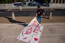 A gun reform activists drags a body bag with the words “How Many more” down the steps of the Tennessee State Capitol building, following the House vote to adopt Senate Bill 1325 which would authorize teachers, principals, and school personnel to carry a concealed handgun on school grounds, in Nashville, Tennessee, U.S., April 23, 2024.  