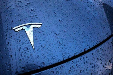 The logo of a Tesla electric vehicle is placed on a car outside a dealership in Drogenbos, Belgium November 25, 2023.