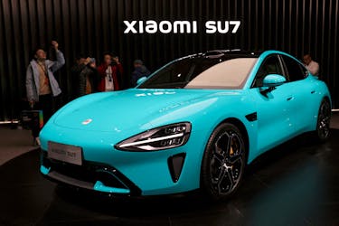 Visitors film around Xiaomi's first electric vehicle, the SU7, displayed at an event in Beijing, China December 28, 2023.