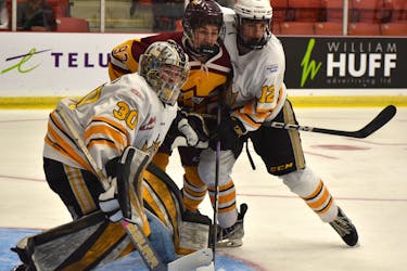 Malcolm MacDonald of the Sydney Mitsubishi Rush battles with Nolan Saunderson of the Brandon Wheat Kings to the side of goaltender Matthew Michta Telus Cup national under-18 hockey championship action at the Membertou Sport and Wellness Centre on Monday. Brandon won the game 7-4. JEREMY FRASER/CAPE BRETON POST