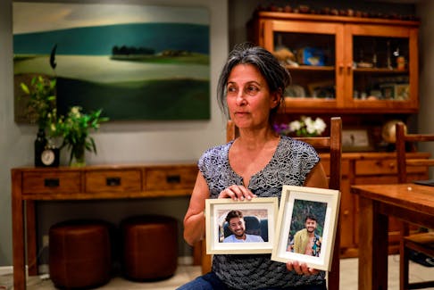 Rachel Goldberg, U.S.-Israeli mother of Hersh Goldberg Polin, which was taken hostage by Hamas militants into the Gaza Strip while attending a music festival in south Israel, holds photos of her son in their home in Jerusalem October 17, 2023