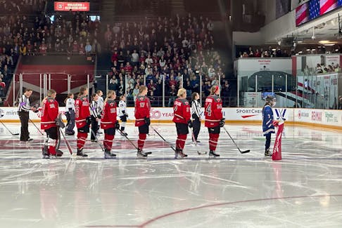 Isabelle Russell stands next to Ottawa forward Hayley Scamurra during the Apr. 20 PWHL game she spent as an anthem skater. Contributed photo