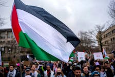 A Palestinian flag flies over a group of pro-Palestinian demonstrators as they march outside the Israeli embassy to call for a ceasefire in Gaza, amid the ongoing conflict between Israel and the Palestinian Islamist group Hamas, during a protest in Washington, U.S., March 2, 2024.