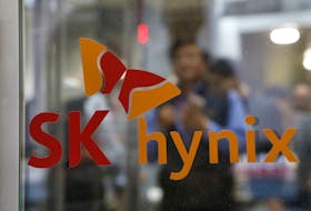 Employee walk past the logo of SK Hynix at its headquarters in Seongnam, South Korea, April 25, 2016.